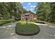 Classic brick home with a circular driveway, fountain, and lush green landscaping creating a serene setting at 9175 Se 7Th Avenue Rd, Ocala, FL 34480