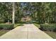 Long driveway leading to a stately brick home with well-manicured landscaping and mature trees at 9175 Se 7Th Avenue Rd, Ocala, FL 34480