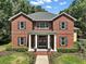 Charming brick home with a welcoming entrance, showcasing classic columns and decorative wreaths on double doors at 9175 Se 7Th Avenue Rd, Ocala, FL 34480