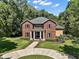 Stately two-story brick home featuring a circular driveway, classic columns, and manicured landscaping at 9175 Se 7Th Avenue Rd, Ocala, FL 34480
