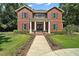 Charming brick home with a welcoming entrance, showcasing classic columns and lush green landscaping at 9175 Se 7Th Avenue Rd, Ocala, FL 34480