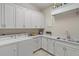 Functional laundry room with washer, dryer, cabinetry, and sink for added convenience at 9175 Se 7Th Avenue Rd, Ocala, FL 34480
