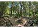 Enjoy the quiet wooded surroundings from this large brick paver patio with fire pit and comfortable chairs for relaxing at 9175 Se 7Th Avenue Rd, Ocala, FL 34480