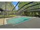 Spacious screened-in pool featuring a charming waterfall and a serene backyard setting at 9175 Se 7Th Avenue Rd, Ocala, FL 34480