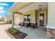 Cozy front porch with comfortable seating, stone detailing, and attractive front door with glass panel at 9203 Sw 97Th Cir, Ocala, FL 34481