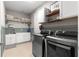Laundry room with modern washer and dryer, sink, and decorative shelving at 9203 Sw 97Th Cir, Ocala, FL 34481
