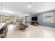 Spacious living room with stylish decor, including tile flooring, modern furniture, and large windows at 9203 Sw 97Th Cir, Ocala, FL 34481