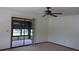 Bright living room featuring carpet flooring, a ceiling fan, and a screened-in lanai at 9960 Sw 103Rd Ln, Ocala, FL 34481