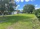 Expansive backyard featuring lush green grass, mature trees, and views of neighboring homes in a quiet community at 10080 Sw 97Th Ct, Ocala, FL 34481