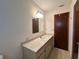 Bathroom vanity area with good lighting, and neutral-colored counter and cabinets at 10080 Sw 97Th Ct, Ocala, FL 34481