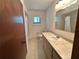 Bathroom vanity area with large mirror, good lighting, and neutral-colored counter and cabinets at 10080 Sw 97Th Ct, Ocala, FL 34481