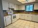 Well-lit kitchen with white cabinets, countertops and tile floors at 10080 Sw 97Th Ct, Ocala, FL 34481