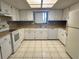 Classic Kitchen featuring white cabinetry, tile flooring, and modern appliances at 10080 Sw 97Th Ct, Ocala, FL 34481