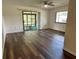 Spacious Living Room featuring wood flooring and access to a screened lanai through sliding glass doors at 10080 Sw 97Th Ct, Ocala, FL 34481