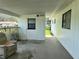 Covered patio with open view to backyard, back door, and an old chair at 10080 Sw 97Th Ct, Ocala, FL 34481