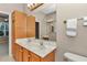A full bathroom features a double sink, marble countertop, oak cabinet, and is illuminated with brass lighting at 11062 Sw 73Rd Ct, Ocala, FL 34476