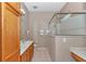 A full bathroom features a marble countertop, tile floor, glass shower with bench, and oak cabinet at 11062 Sw 73Rd Ct, Ocala, FL 34476