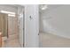 An open bathroom door reveals a sink, tub, and shower, leading to a carpeted bedroom with a ceiling fan and closet at 11062 Sw 73Rd Ct, Ocala, FL 34476