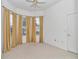 Bright bedroom with neutral carpet, ceiling fan, and a large window with privacy blinds at 11062 Sw 73Rd Ct, Ocala, FL 34476