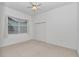 A carpeted bedroom is bright with a window, ceiling fan, and a double-door closet at 11062 Sw 73Rd Ct, Ocala, FL 34476