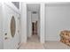 A white front door opens to a foyer with tile floor that flows into the carpeted living space and hallway at 11062 Sw 73Rd Ct, Ocala, FL 34476
