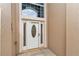 Home's bright white front door with leaded glass window flanked by sidelights and transom window at 11062 Sw 73Rd Ct, Ocala, FL 34476
