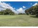 Expansive green golf course view showcases flags, lush trees, and a pond under a blue sky at 11062 Sw 73Rd Ct, Ocala, FL 34476