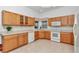 Bright kitchen with wood cabinets, white appliances, and tiled flooring at 11062 Sw 73Rd Ct, Ocala, FL 34476