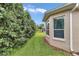 Landscaped side yard with a well-maintained lawn and privacy hedge, enhancing the home's curb appeal and outdoor space at 11062 Sw 73Rd Ct, Ocala, FL 34476