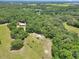 Expansive aerial view of lush wooded acreage featuring a home with abundant privacy and beautiful surrounding greenery at 12080 Se Sunset Harbor Rd, Weirsdale, FL 32195
