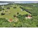 Aerial view showcasing the house location on a property with natural and cultivated green spaces at 12080 Se Sunset Harbor Rd, Weirsdale, FL 32195