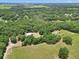Vast aerial view of a property with sprawling greenery, dense forests, and open fields at 12080 Se Sunset Harbor Rd, Weirsdale, FL 32195