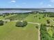 Expansive aerial view of lush green fields, trees, and a distant lake at 12080 Se Sunset Harbor Rd, Weirsdale, FL 32195