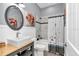 Updated bathroom with a decorative mirror, wooden vanity, and a shower with a stylish shower curtain at 12080 Se Sunset Harbor Rd, Weirsdale, FL 32195