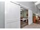 Bedroom view through modern sliding barn doors features a cozy bed and wood floors at 12080 Se Sunset Harbor Rd, Weirsdale, FL 32195