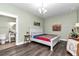 Bedroom featuring wood floors, soothing wall color, comfortable bed, and en-suite bathroom at 12080 Se Sunset Harbor Rd, Weirsdale, FL 32195