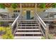 Front entrance to the home with wooden steps leading up to a covered porch at 12080 Se Sunset Harbor Rd, Weirsdale, FL 32195