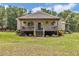 Charming home featuring a welcoming porch with hanging plants and a manicured lawn at 12080 Se Sunset Harbor Rd, Weirsdale, FL 32195