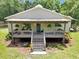Inviting home with a cozy front porch, hanging ferns, and well-maintained landscaping at 12080 Se Sunset Harbor Rd, Weirsdale, FL 32195