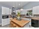 Bright kitchen features a butcher block island with seating, white cabinets and stainless steel appliances at 12080 Se Sunset Harbor Rd, Weirsdale, FL 32195