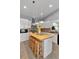 Bright kitchen features a butcher block island with seating, white cabinets and stainless steel appliances at 12080 Se Sunset Harbor Rd, Weirsdale, FL 32195