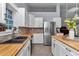 Kitchen featuring butcher block counters, stainless steel appliances, and white cabinets at 12080 Se Sunset Harbor Rd, Weirsdale, FL 32195