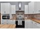 Kitchen featuring stainless steel appliances, white cabinets, tile backsplash, and butcher block countertops at 12080 Se Sunset Harbor Rd, Weirsdale, FL 32195