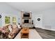 Cozy living room with a stone fireplace, beamed mantle, and comfortable seating at 12080 Se Sunset Harbor Rd, Weirsdale, FL 32195