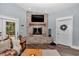 Cozy living room with a stone fireplace, beamed mantle, and comfortable seating at 12080 Se Sunset Harbor Rd, Weirsdale, FL 32195