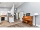 Bright living room showcasing a grand piano, light gray walls, and access to other rooms at 12080 Se Sunset Harbor Rd, Weirsdale, FL 32195