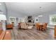 Spacious living and dining area with fireplace, wood floors, and ample natural light at 12080 Se Sunset Harbor Rd, Weirsdale, FL 32195