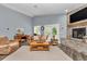 Bright living room with comfortable seating, a cozy fireplace, and a neutral color palette at 12080 Se Sunset Harbor Rd, Weirsdale, FL 32195