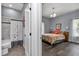 Combination bathroom and bedroom suite with stone tile shower and wood flooring at 12080 Se Sunset Harbor Rd, Weirsdale, FL 32195