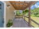 Cozy porch featuring a swing bench, wood decking, and views of the surrounding greenery at 12080 Se Sunset Harbor Rd, Weirsdale, FL 32195